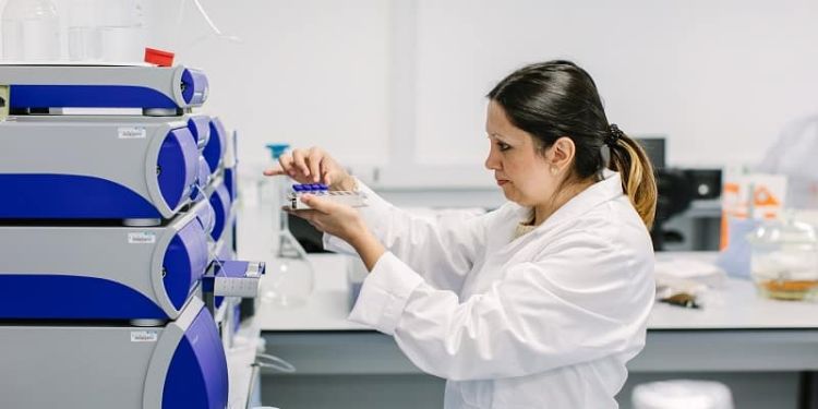 Researcher loading samples into analysis machine