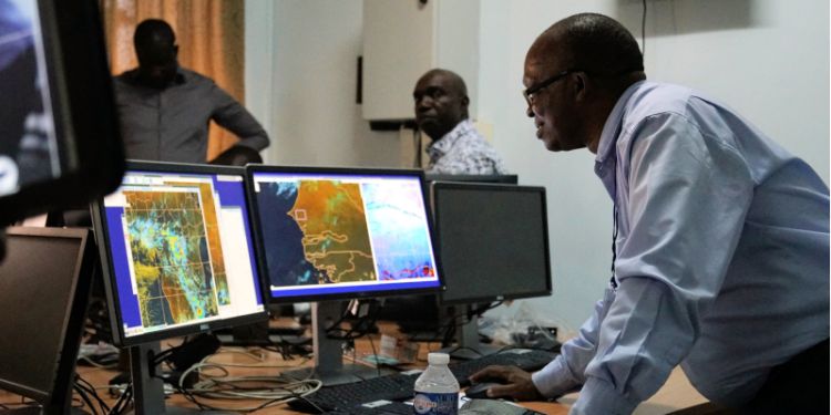 Weather scientists examining data on computer screens.