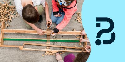 Four children putting together pieces of the inside of a piano. Be Curious logo on the right.