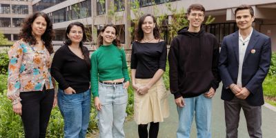A group of six practitioners of research, art and activism from Buenos Aires and Leeds, stood together in a line in front of the sustainable garden in Leeds.