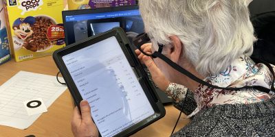 Someone holding a tablet, looking at a nutrition label on an supermarket website.