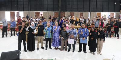 A large group of people at the toolkit launch event in Indonesia. They're all holding up their little finger, many are smiling.