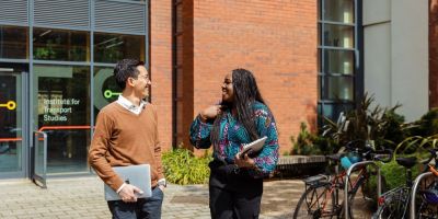 Two Masters students chatting outside the Institute for Transport Studies.