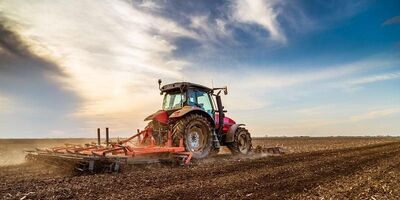 Tractor ploughing a field on a sunny day.