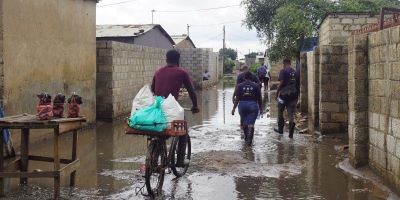 Someone cycling through a flooded street in southern Africa