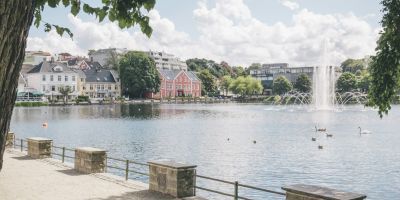 A body of water with a fountain in the middle, and neat buildings surrounding it, in Stavanger, Norway