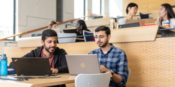 Students on laptop in Roger Stevens lecture theatre