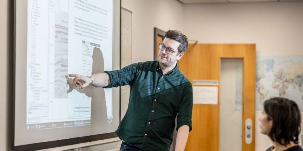 Masters students looking at whiteboard in SEE