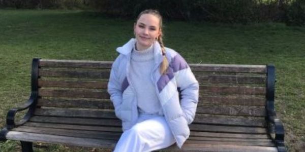 Image of undergraduate Geography student Ella Ferguson sat on a bench.