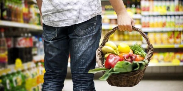Man in supermarket with basket of vegetables