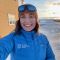 Sally smiling into the camera, dressed in Arctic fieldwork gear at the Ny-Alesund research base