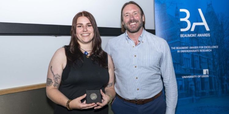 Isabelle Wicks holding her Beaumont award and smiling at the camera.