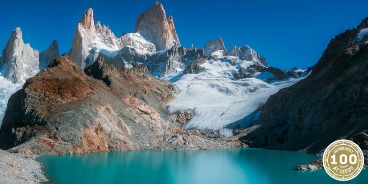 A photograph of a mountain with a clear blue tarn.