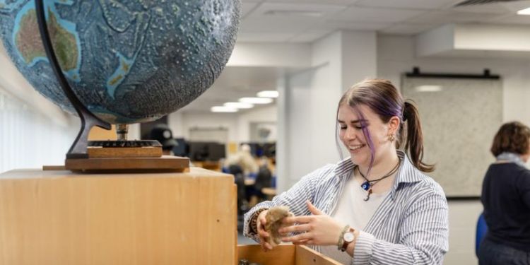 Student looking at rocks in the Earth Visualisation Laboratory, School of Earth and Environment