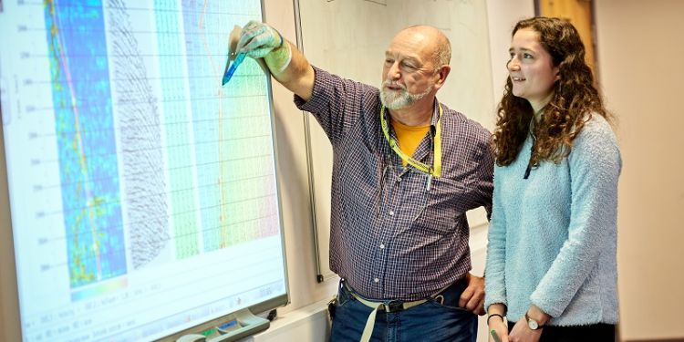 staff and student studying seismic chart